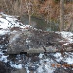 Połamana płyta betonowa na brzegu rzeki