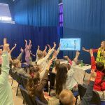 Dzieci podnoszące ręce do góry na wykładzie WIOŚ